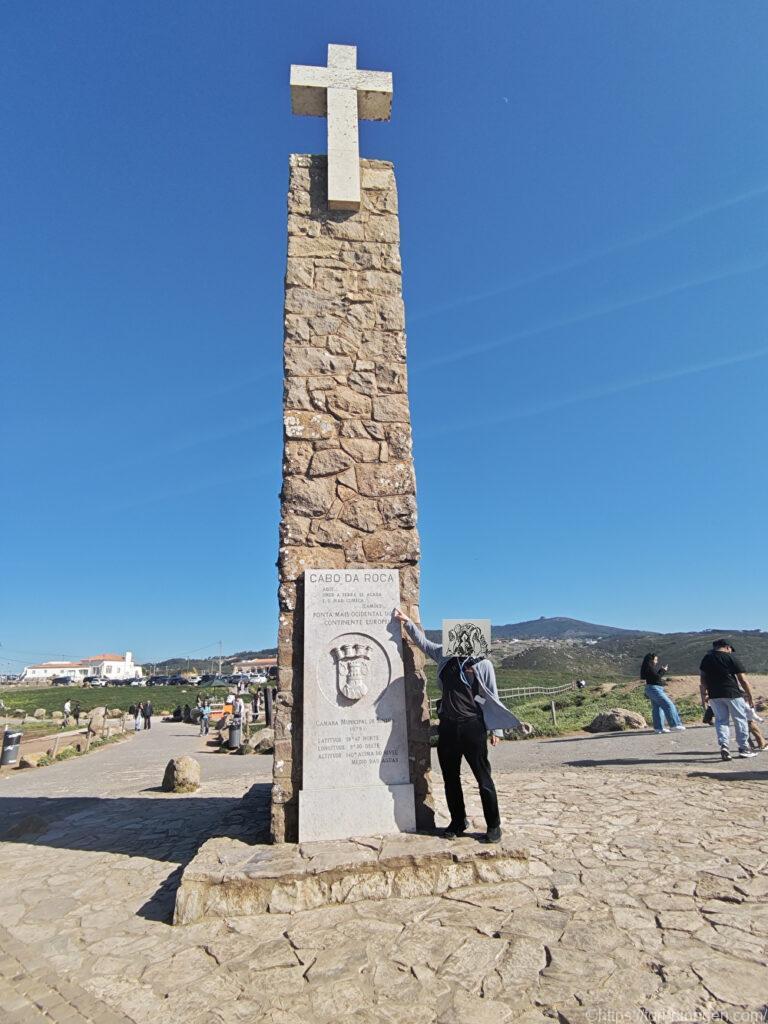 石碑前でポーズをとる鳥人間