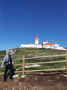 灯台の前でポーズをとる鳥人間